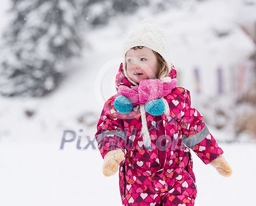 portrait of happy smiling little girl child outdoors having fun and playing on snowy winter day