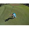 top view of golf player hitting shot with club on course at beautiful morning