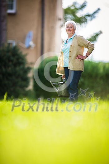 Senior woman doing some gardening in her lovely garden Senior woman doing some gardening in her lovely garden