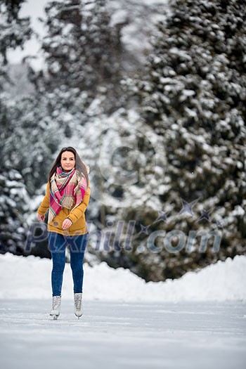 Young woman ice skating outdoors on a pond on a freezing winter day (color toned image; motion blurred image) Young woman ice skating outdoors on a pond on a freezing winter day (color toned image; motion blurred image)
