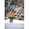 Young woman ice skating outdoors on a pond on a freezing winter day (color toned image; motion blurred image)