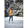 Young woman ice skating outdoors on a pond on a freezing winter day (color toned image; motion blurred image)