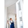 Painter man at work with a paint bucket, wall painting concept