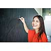 Pretty, young college student writing on the chalkboard/blackboard during a math class