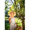 Pretty, young woman gardening in her garden - harvesting organic apples - looking very happy with the results