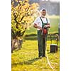 Portrait of senior man gardening, taking care of his lovely orchard, ejoying actively his retirement
