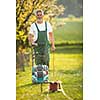 Portrait of senior man gardening, taking care of his lovely orchard, ejoying actively his retirement