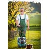 Portrait of senior man gardening, taking care of his lovely orchard, ejoying actively his retirement