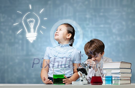 Two cute children at chemistry lesson making experiments Two cute children at chemistry lesson making experiments