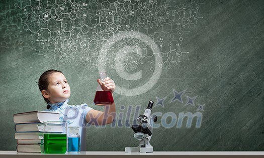 Cute school girl at chemistry lesson with test tube Cute school girl at chemistry lesson with test tube