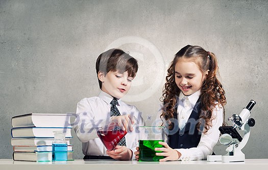 Two cute children at chemistry lesson making experiments Two cute children at chemistry lesson making experiments