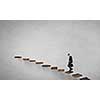 Businessman walking on career ladder made of books