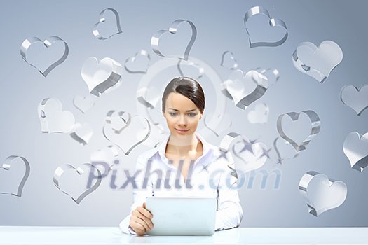 Attractive businesswoman sitting at table and using tablet Attractive businesswoman sitting at table and using tablet