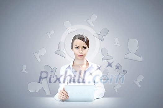 Attractive businesswoman sitting at table and using tablet Attractive businesswoman sitting at table and using tablet
