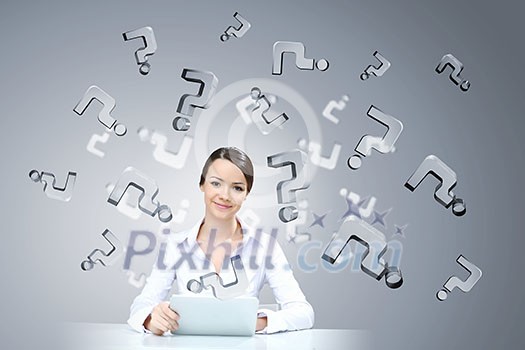 Attractive businesswoman sitting at table and using tablet Attractive businesswoman sitting at table and using tablet