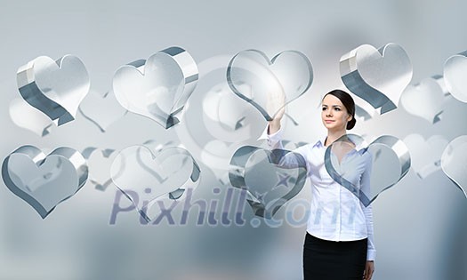 Attractive businesswoman touching high tech heart icon Attractive businesswoman touching high tech heart icon