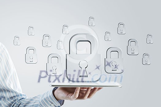 Close up of businessman hand holding tablet and glass symbols Close up of businessman hand holding tablet and glass symbols