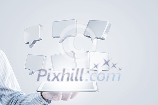 Close up of businessman hand holding tablet and glass speech symbols Close up of businessman hand holding tablet and glass speech symbols