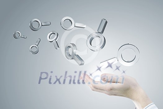 Businessman hand holding search glass icons in palm Businessman hand holding search glass icons in palm