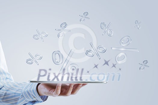 Close up of businessman hand holding tablet and glass symbols Close up of businessman hand holding tablet and glass symbols