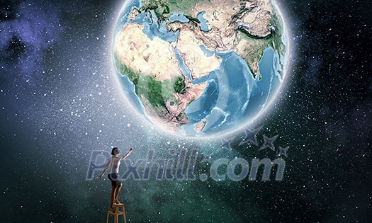 Businesswoman standing on chair and reaching Earth planet. Elements of this image are furnished by NASA Businesswoman standing on chair and reaching Earth planet. Elements of this image are furnished by NASA