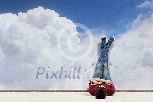 Young man lying on floor with legs raised up