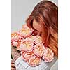 red-haired girl sniffing a bouquet of pink roses, the concept of a valentine's day