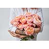 a bouquet of pink roses a woman with a tattoo is holding in her hands. The valentine's day