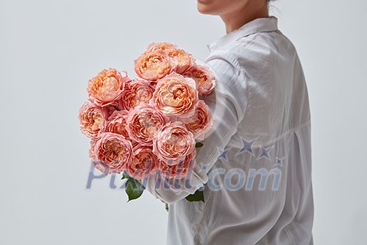 A very beautiful bouquet of pink roses is held by a woman. the best gift for a girl in Valentine's Day. A very beautiful bouquet of pink roses is held by a woman. the best gift for a girl in Valentine's Day.