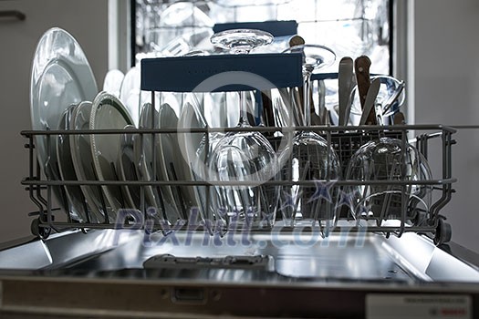 Open dishwasher with clean glass and dishes selective focus Clean glasses after washing in the dishwasher. Open dishwasher with clean glass and dishes selective focus Clean glasses after washing in the dishwasher.