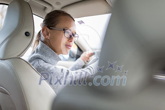 Pretty, young woman driving her new car (color toned image; shallow DOF) Pretty, young woman driving her new car (color toned image; shallow DOF)
