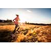 Young woman running outdoors on a lovely sunny winter/fall day (motion blurred image)