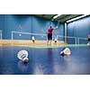 badminton - badminton courts with players competing; shuttlecocks in the foreground (shallow DOF; color toned image)