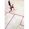 Two female squash players in fast action on a squash court (motion blurred image; color toned image)
