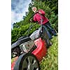 Senior man mowing the lawn in his garden