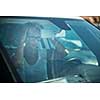 Pretty, young woman  driving her car - making sure her hair looks perfect in the mirror (shallow DOF; color toned image)