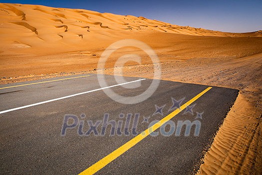 Modernity versus nature concept - end of civilisation, beginning of desert. Modern paved highway ending up in sand dunes. Modernity versus nature concept - end of civilisation, beginning of desert. Modern paved highway ending up in sand dunes.