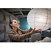 Pretty, young woman choosing the right lamp for her apartment in a modern home furnishings store (color toned image; shallow DOF)
