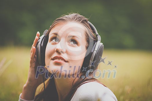 portrait of a pretty young woman listening to music on her mp3 player outdoors (daydreaming) portrait of a pretty young woman listening to music on her mp3 player outdoors (daydreaming)