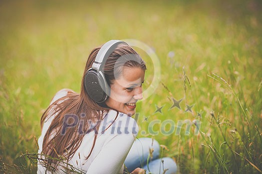 portrait of a pretty young woman listening to music on her mp3 player outdoors (daydreaming) portrait of a pretty young woman listening to music on her mp3 player outdoors (daydreaming)