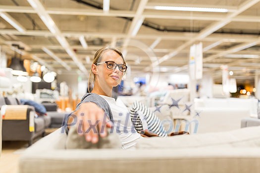 Pretty, young woman choosing the right furniture for her apartment in a modern home furnishings store (color toned image; shallow DOF) Pretty, young woman choosing the right furniture for her apartment in a modern home furnishings store (color toned image; shallow DOF)