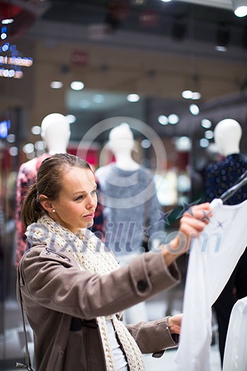 Young woman shopping in a fashion store (color toned image; shallow DOF) Young woman shopping in a fashion store (color toned image; shallow DOF)