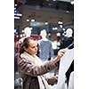 Young woman shopping in a fashion store (color toned image; shallow DOF)