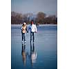 Couple ice skating outdoors on a pond on a lovely sunny winter day