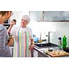 Senior woman/grandmother cooking in a modern kitchen (shallow DOF; color toned image)