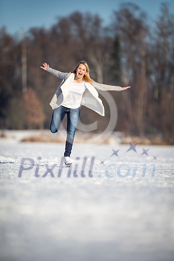 Young woman ice skating outdoors on a pond on a freezing winter day (color toned image; motion blurred image) Young woman ice skating outdoors on a pond on a freezing winter day (color toned image; motion blurred image)