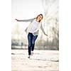 Young woman ice skating outdoors on a pond on a freezing winter day (color toned image; motion blurred image)