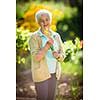 Senior woman doing some gardening in her lovely garden - watering the plants