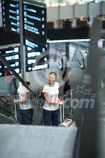 Young female passenger at the airport, transfering to her gate to board her flight on time(color toned image) Young female passenger at the airport, transfering to her gate to board her flight on time(color toned image)