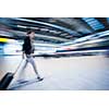 Pretty young female passenger at the airport (shallow DOF; color toned image, motion bkurred image)